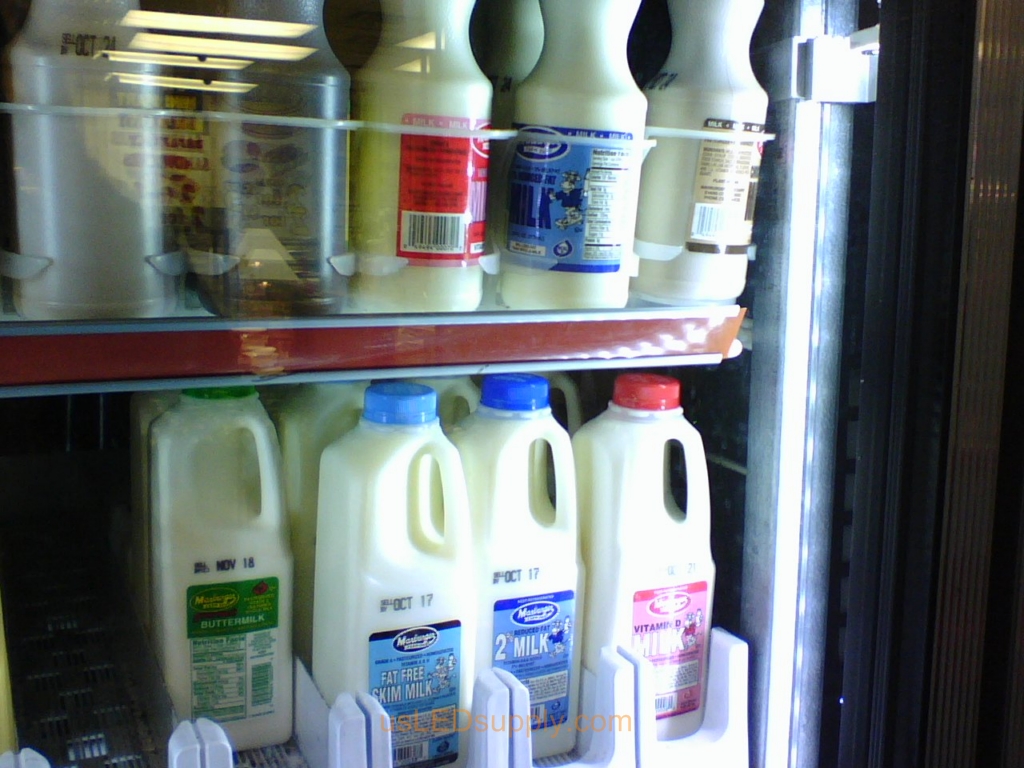Milk in a gas station cooler lit up with cool white flexible LED strips.