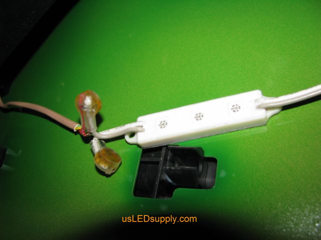 Close up of green LED module installed under a John Deere tractor.