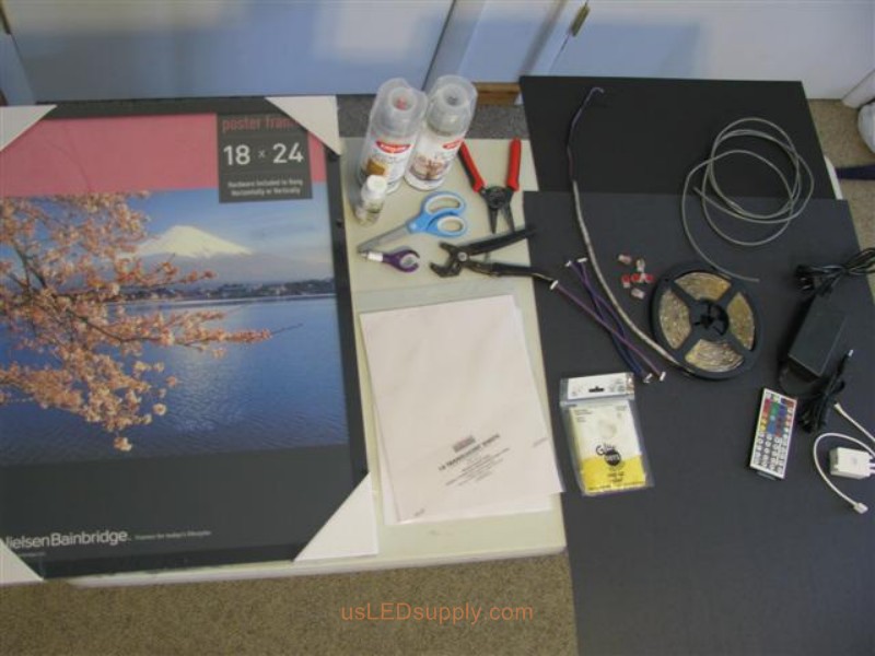 Materials for the LED Silhouette Project including poster frame, glue, paper, and RGB LED strip.