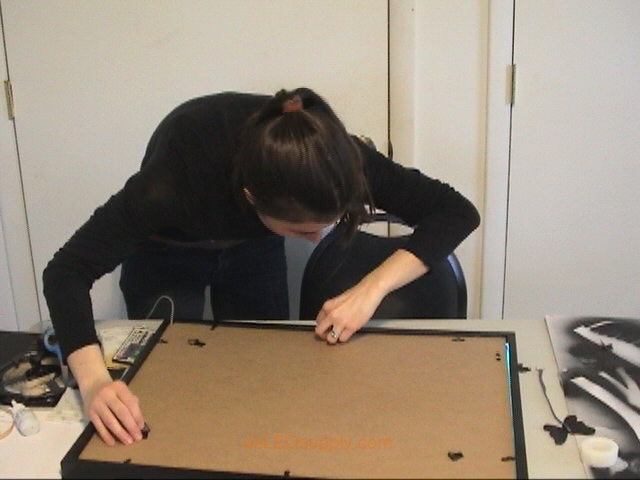 Closing the back of the poster frame.
