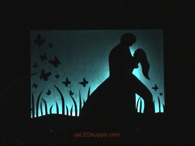 RGB LED silhouette art project with couple in love set on light blue color.