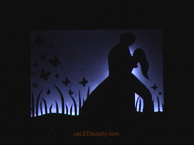 RGB LED silhouette art project with couple in love set on blue color.