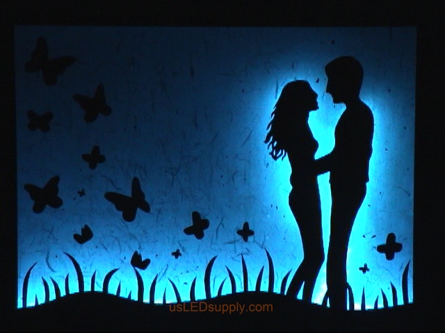 LED Silhouette Art set aglow with color Changing RGB LED lights set on light blue.