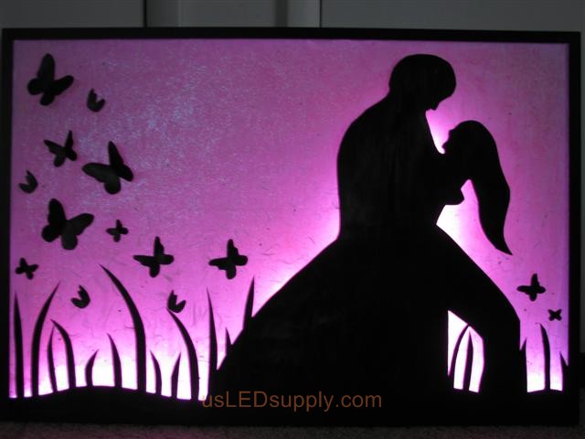 RGB LED silhouette art project with couple in love set on pink color.
