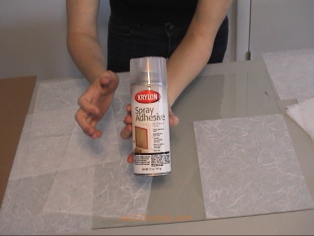 Use spray adhesive or gluestick to attach transluscent paper to glass.