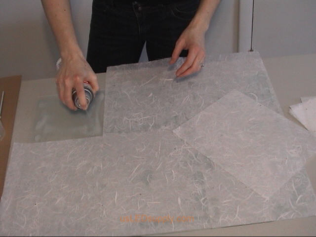 Use spray adhesive or gluestick to attach transluscent paper to glass.