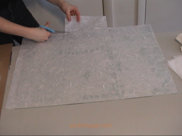 Cut off excess paper around the edges of the glass.