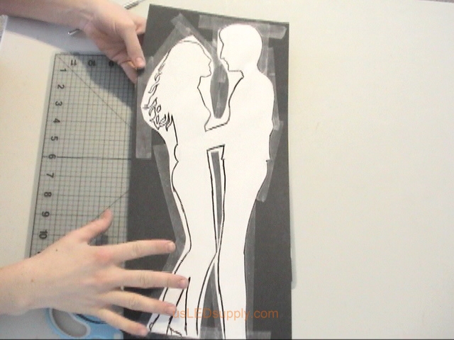 Put your design on a cutting mat and cut around the outline of the silhouette with scissors and exacto knife.