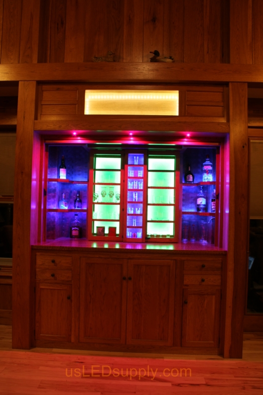 RGB LED Strips illuminate the shelves of this home bar.