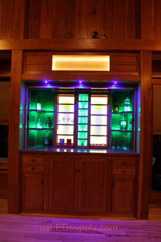 RGB LED Strips illuminate the shelves of this home bar.