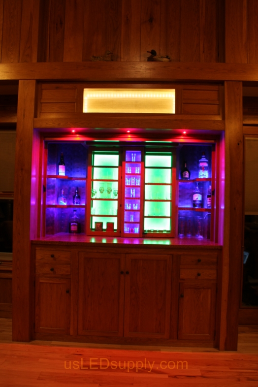 RGB LED Strips illuminate the shelves of this home bar.