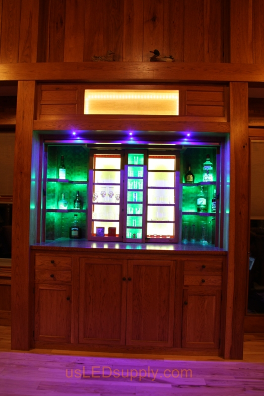 RGB LED Strips illuminate the shelves of this home bar.