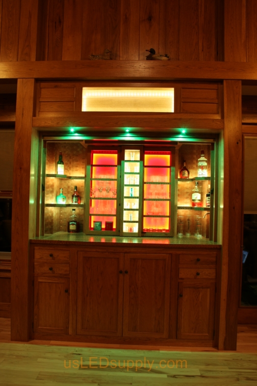 RGB LED Strips illuminate the shelves of this home bar.