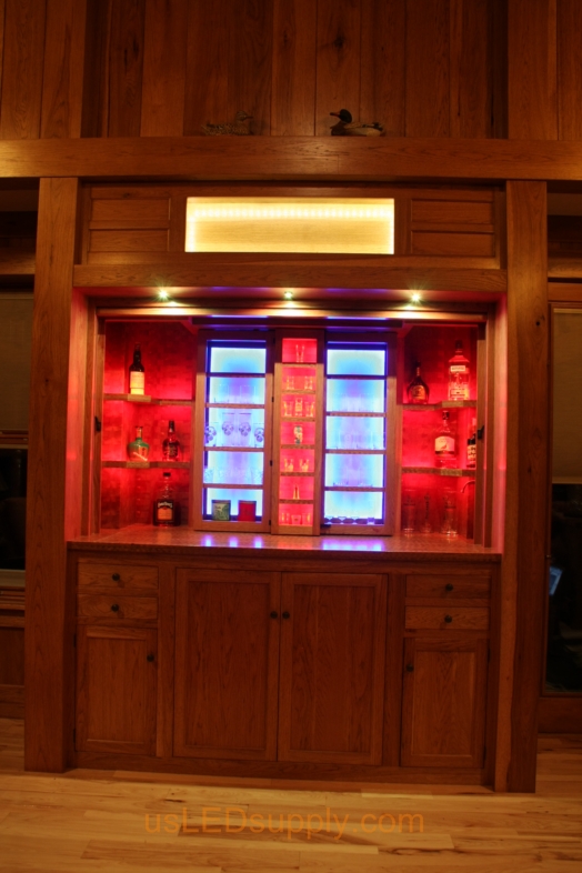 RGB LED Strips illuminate the shelves of this home bar.