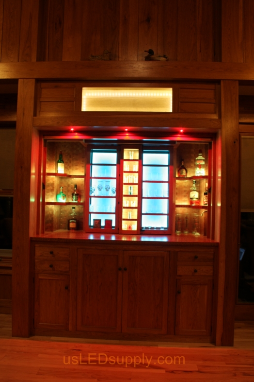 RGB LED Strips illuminate the shelves of this home bar.