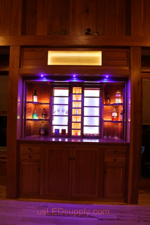 RGB LED Strips illuminate the shelves of this home bar.