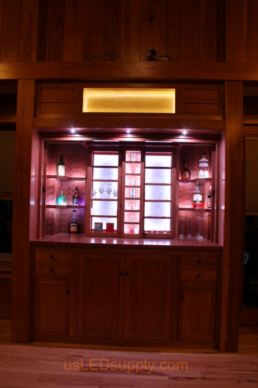 RGB LED Strips illuminate the shelves of this home bar.