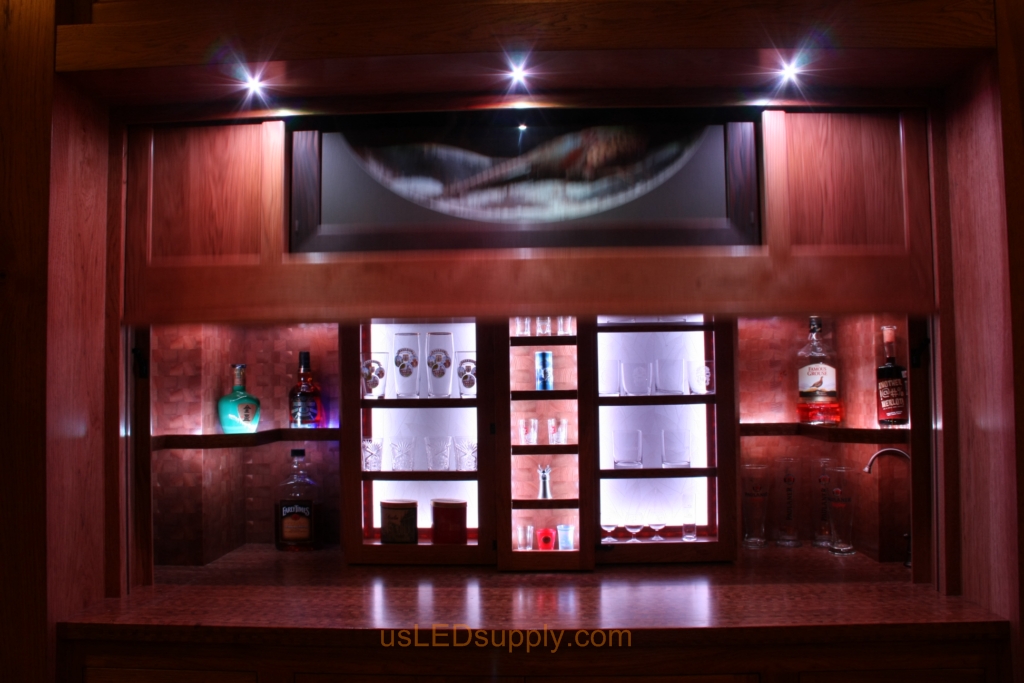 The panel is mechanically raised to reveal the liquer cabinets and a window overlooking the lake.