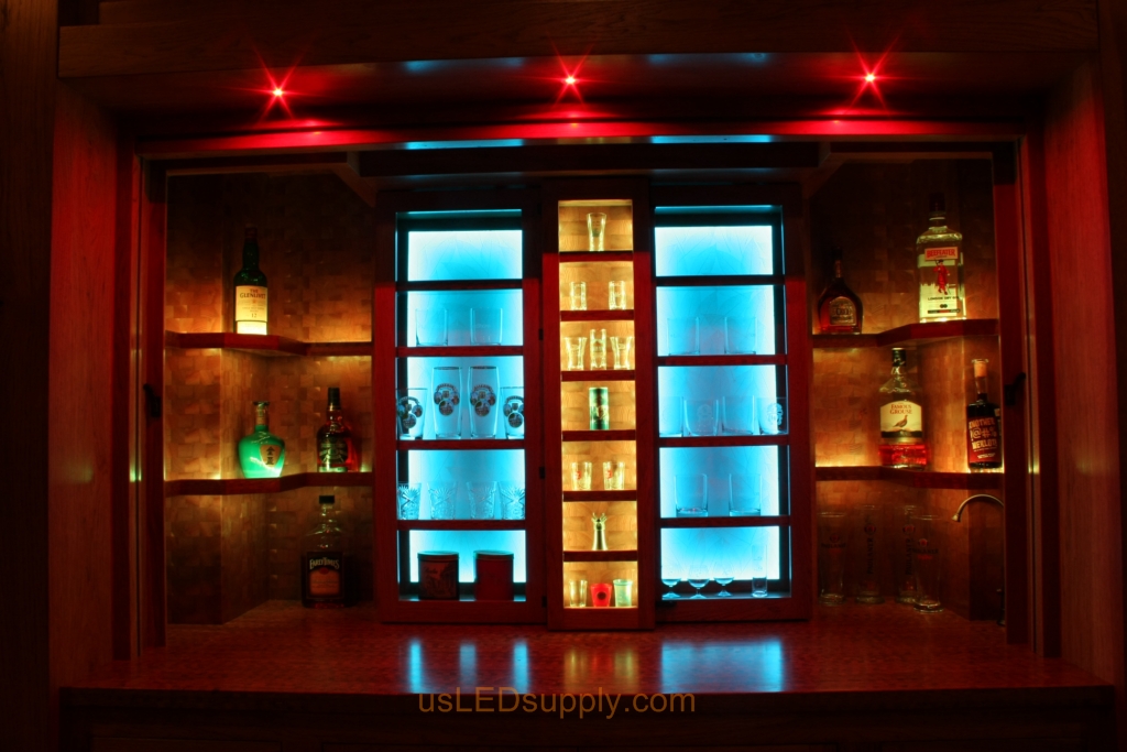RGB LED Strips in different zones create color effects on this home bar shelving.