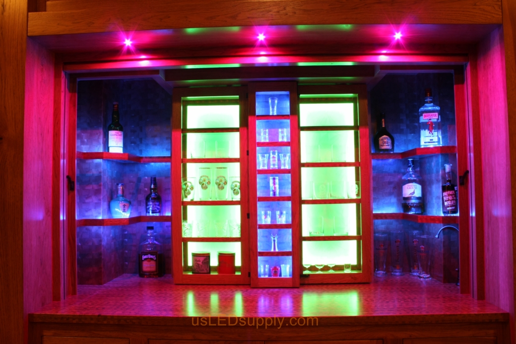 RGB LED Strips in different zones create color effects on this home bar shelving.