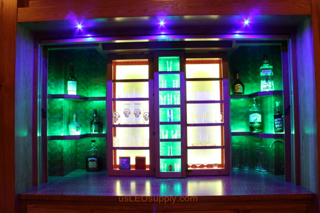 RGB LED Strips in different zones create color effects on this home bar shelving.