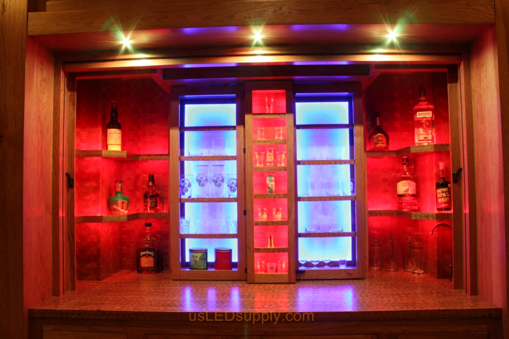 RGB LED Strips in different zones create color effects on this home bar shelving.