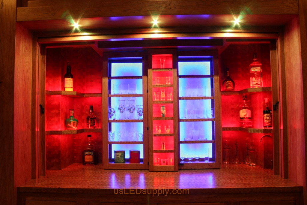 RGB LED Strips in different zones create color effects on this home bar shelving.