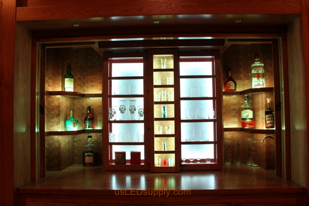 RGB LED Strips in different zones create color effects on this home bar shelving.