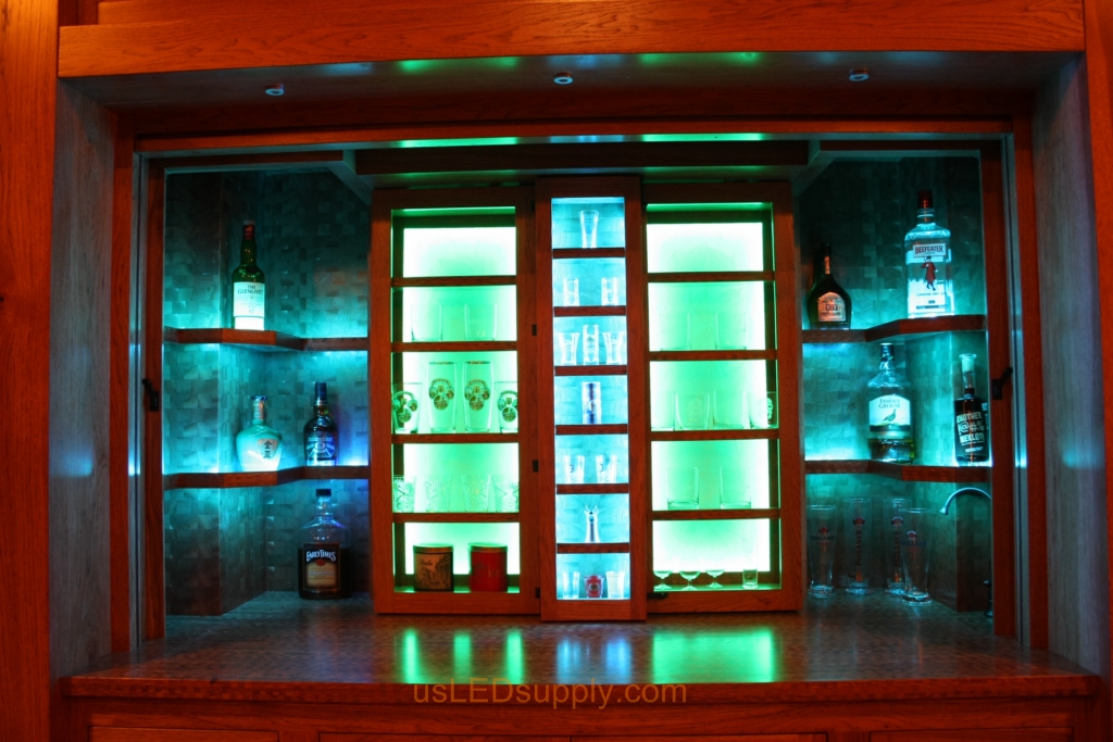 RGB LED Strips in different zones create color effects on this home bar shelving.