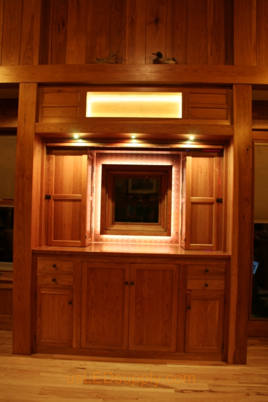 The panel is mechanically raised to reveal the liquer cabinets and a window overlooking the lake.
