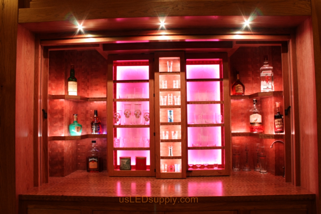 RGB LED Strips in different zones create color effects on this home bar shelving.