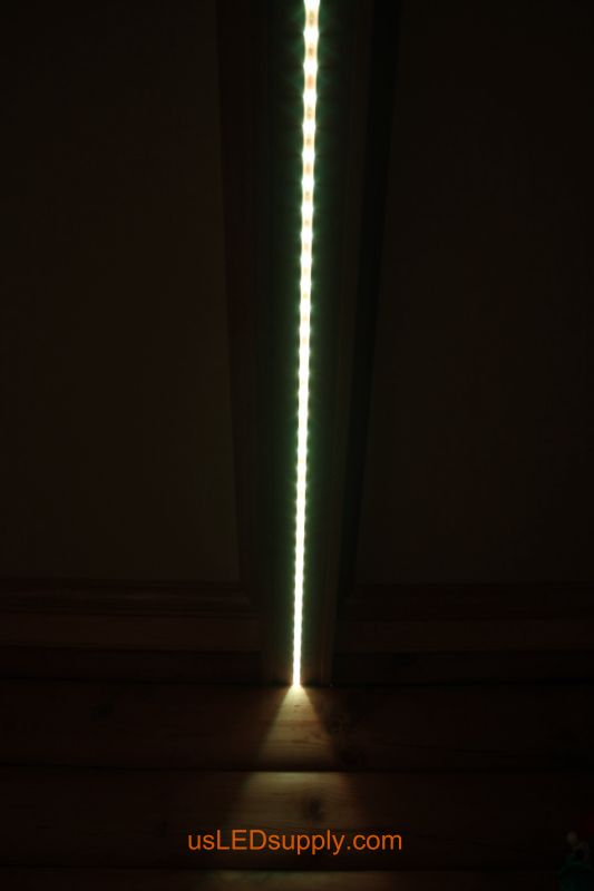Close up of LED strip running along the beam in a log cabin living room.  
