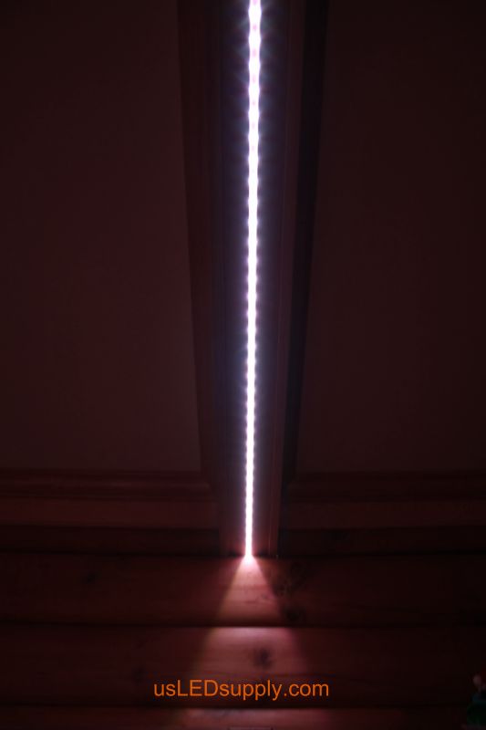 Close up of LED strip running along the beam in a log cabin living room.  
