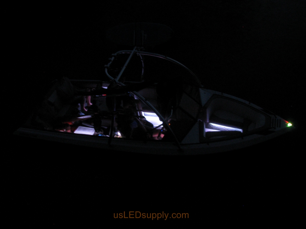 Malibu Sunsetter Boat on the water at night with RGB color changing LEDs lighting up the interior.