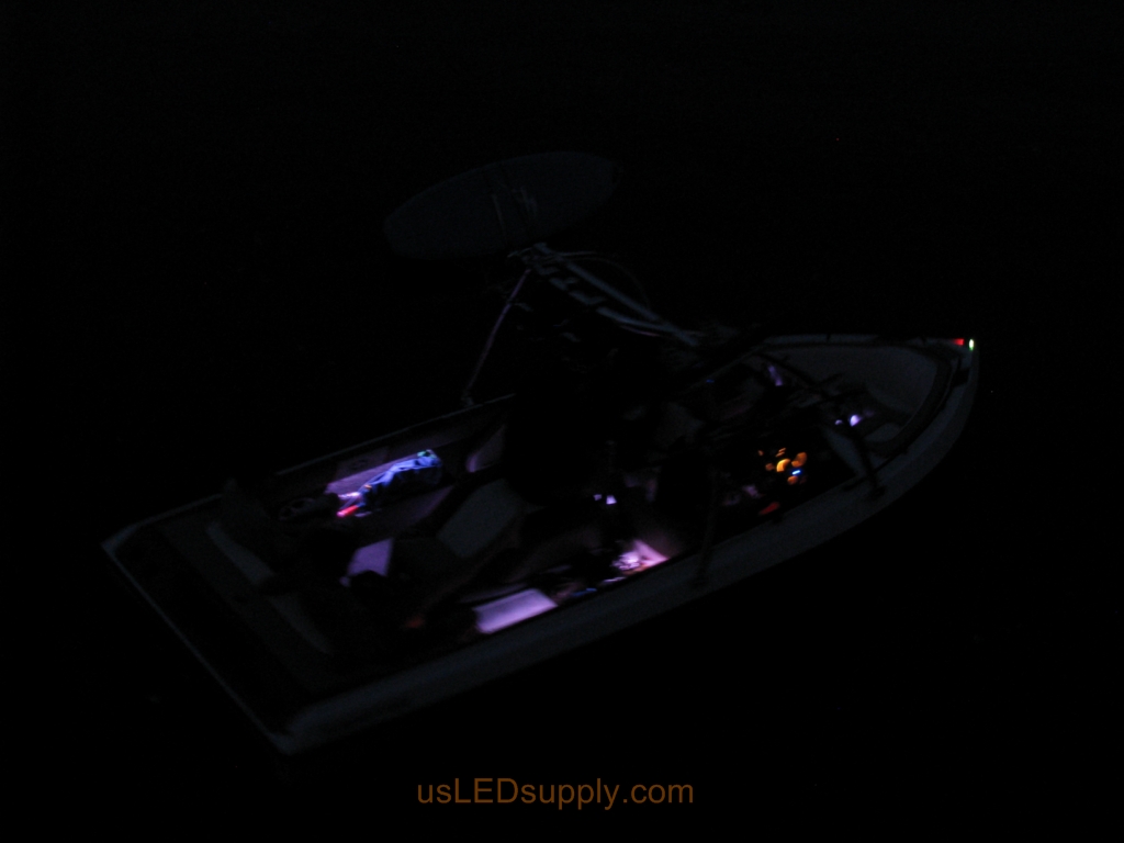 Malibu Sunsetter Boat on the water at night with RGB color changing LEDs lighting up the interior.