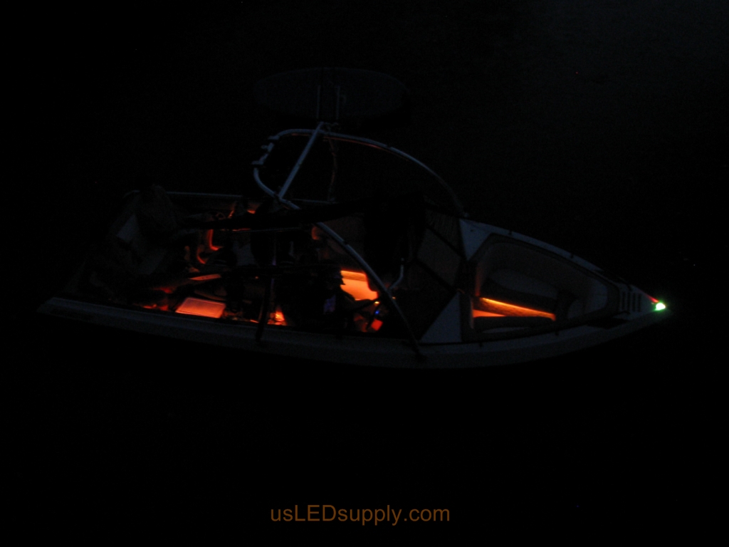 Malibu Sunsetter Boat on the water at night with RGB color changing LEDs lighting up the interior.