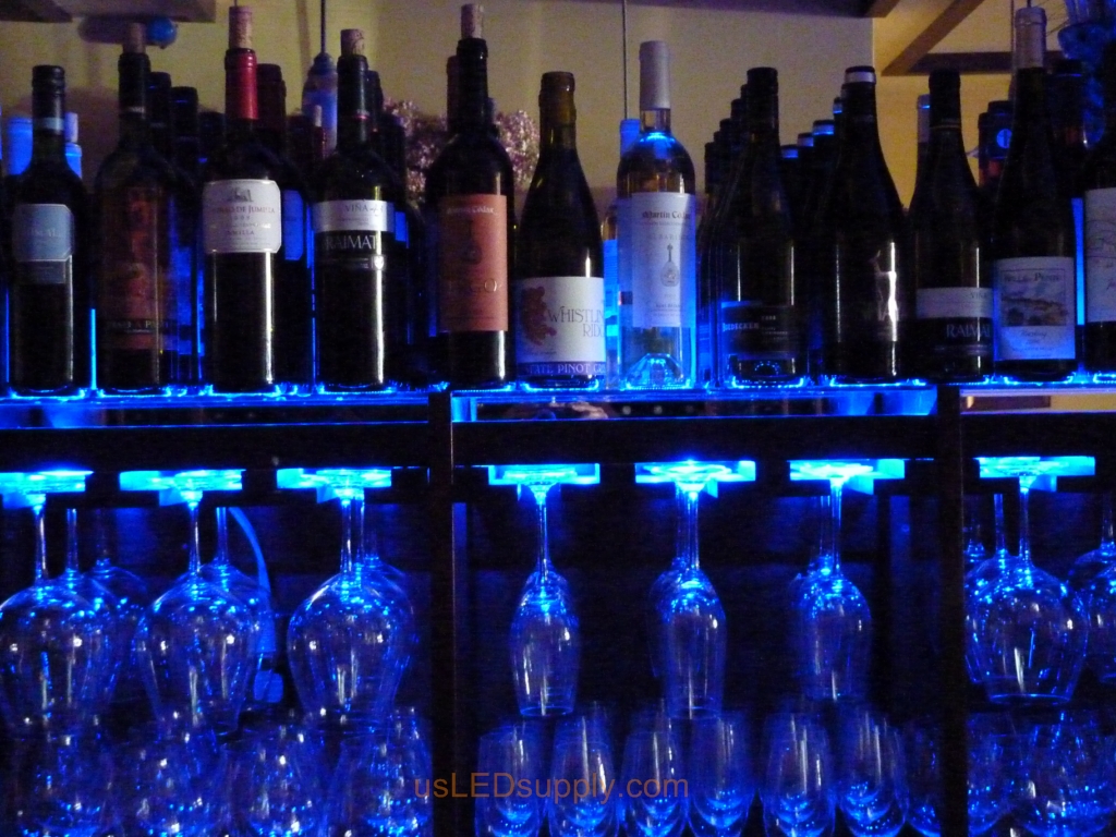 Glass shelving in bar with RGB flexible LED strips behind them makes the glass shelving and bottles glow.