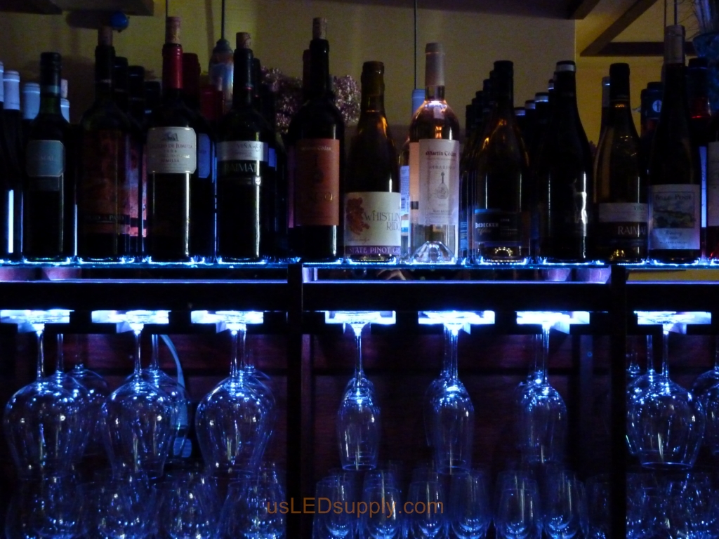 Glass shelving in bar with RGB flexible LED strips behind them makes the glass shelving and bottles glow.