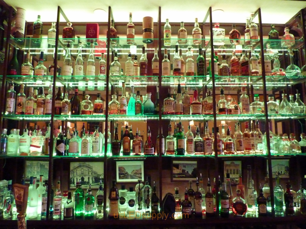 Glass shelving in bar with RGB flexible LED strips behind them makes the glass shelving and bottles glow.