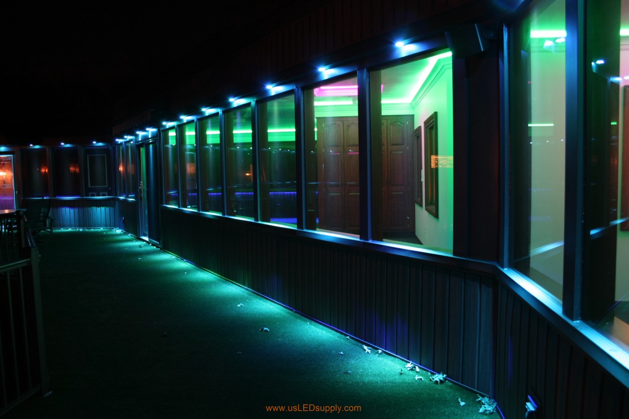 RGB LED puck lights above windows of a glassed in walkway.