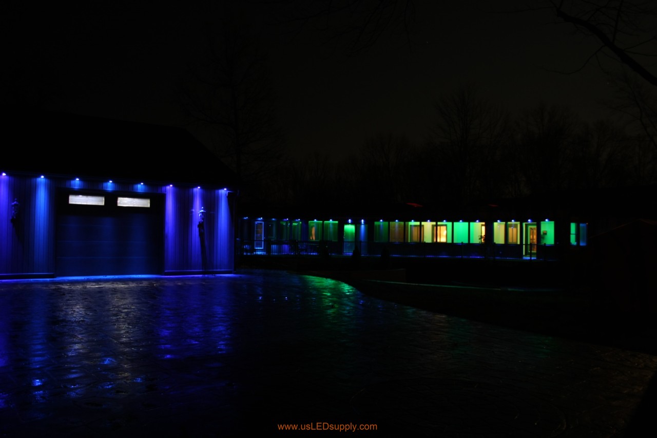 RGB Puck Lights outside of a garage and above enclosed glass walkway windows.