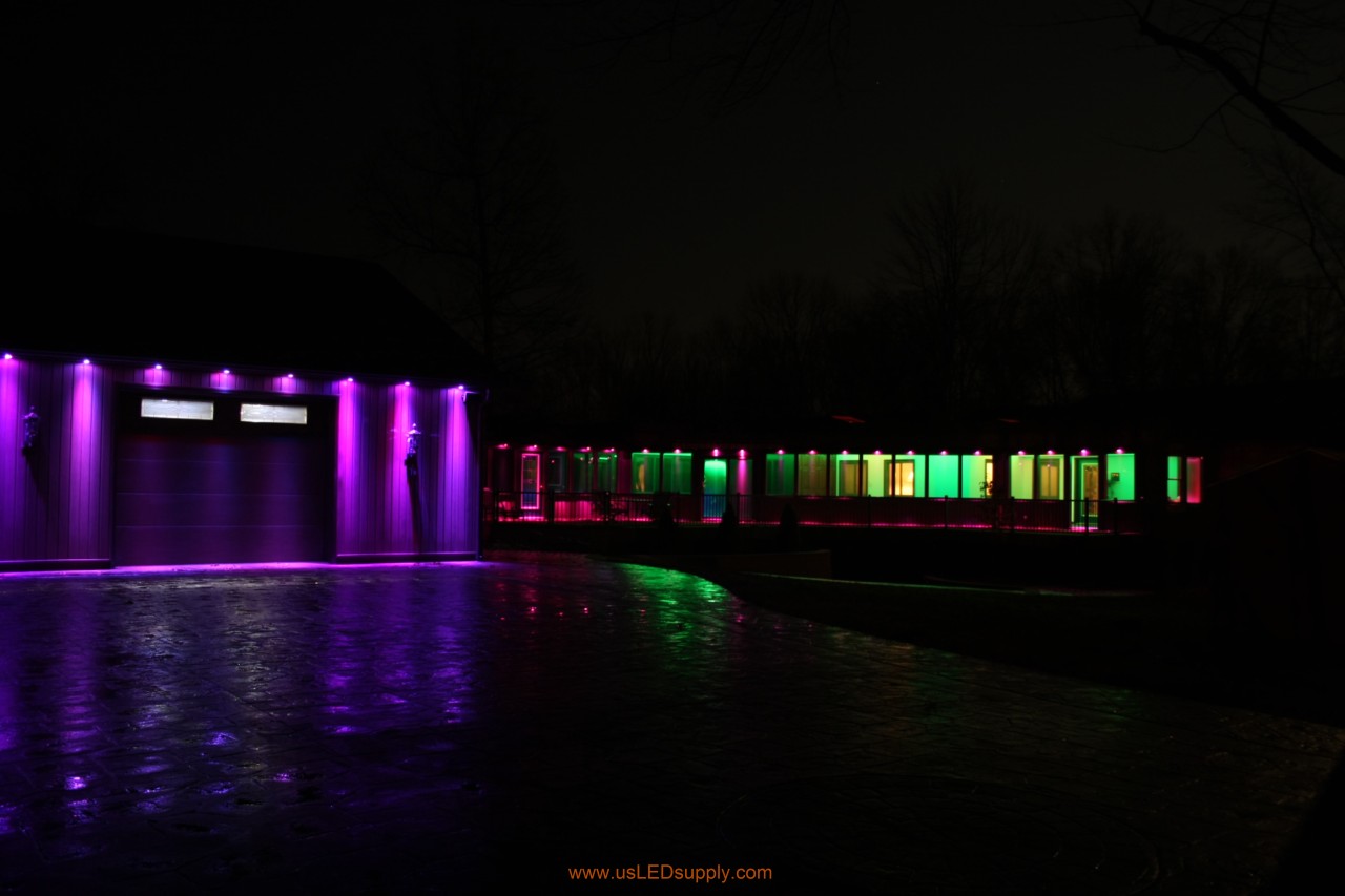 RGB Puck Lights outside of a garage and above enclosed glass walkway windows.