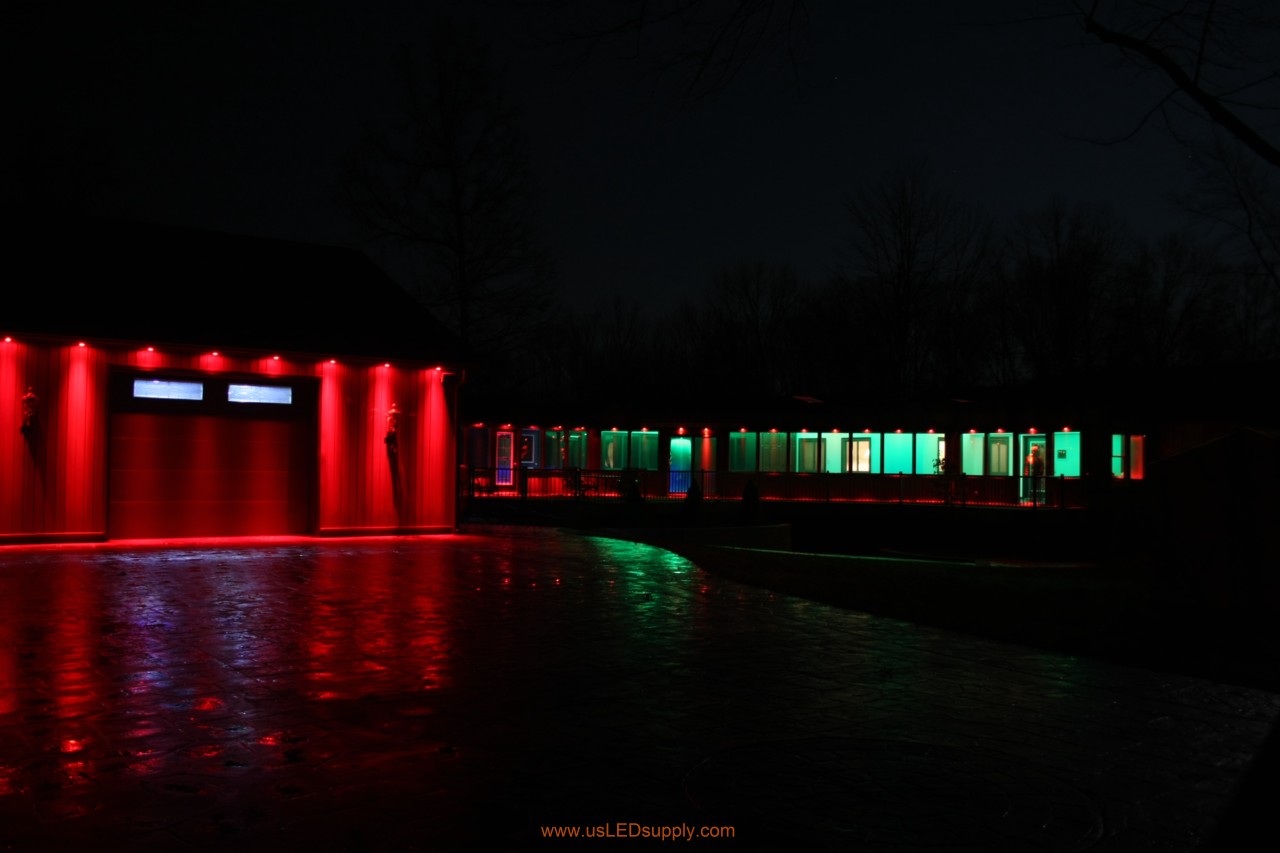 RGB Puck Lights outside of a garage and above enclosed glass walkway windows.