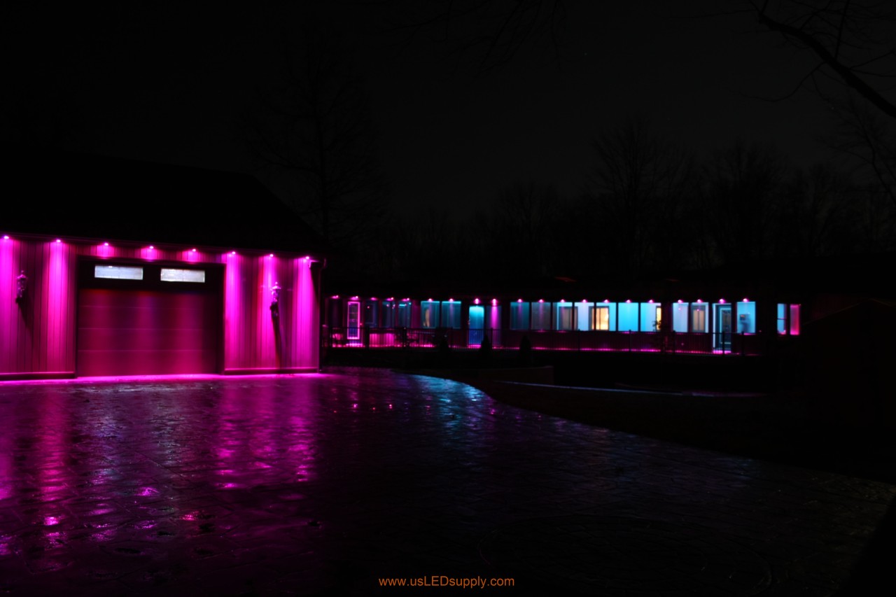 RGB Puck Lights outside of a garage and above enclosed glass walkway windows.
