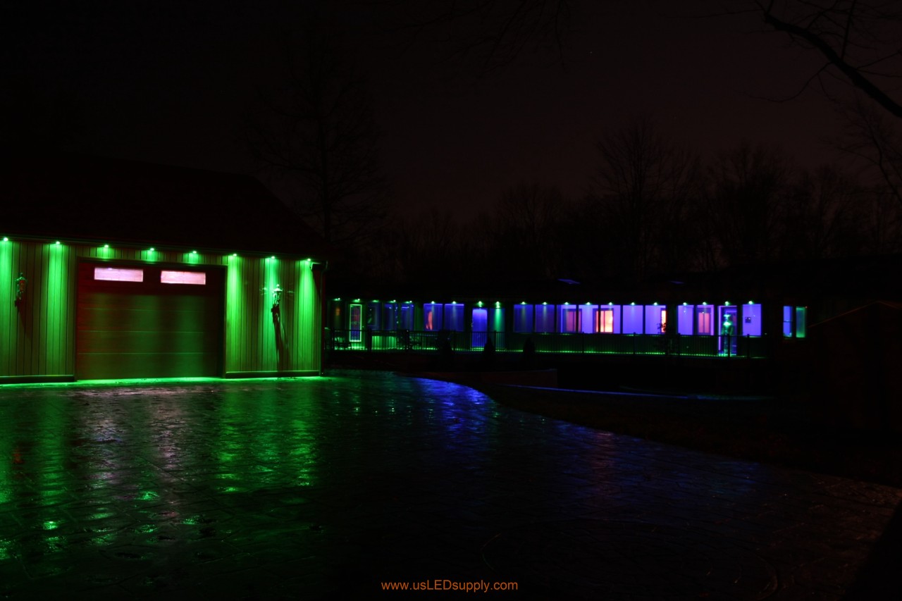 RGB Puck Lights outside of a garage and above enclosed glass walkway windows.