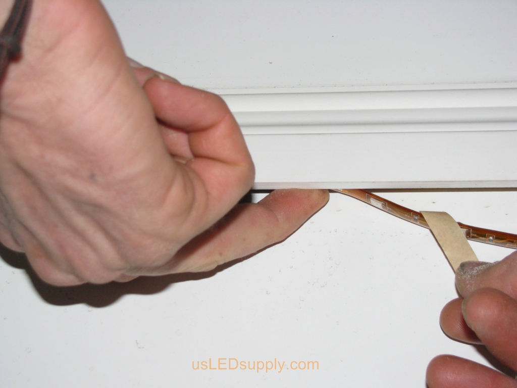 Installing flexible LED strip under chair rail.