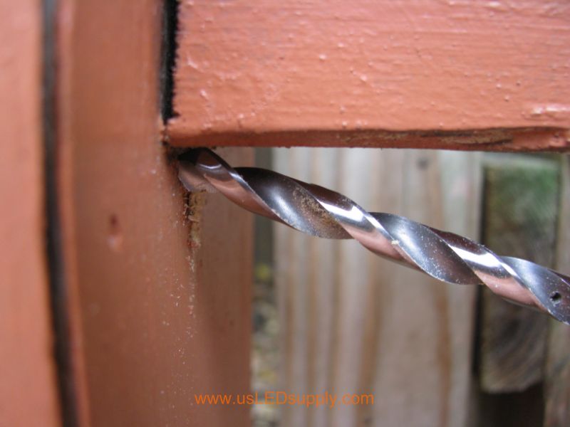 Drilling through a Deck Post in order to run wire through it.