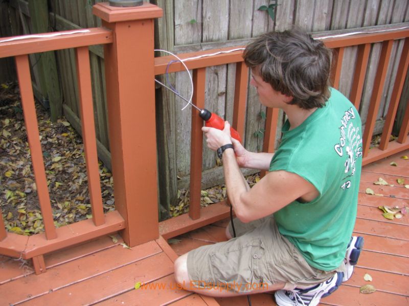 Drilling through a Deck Post in order to run wire through it.