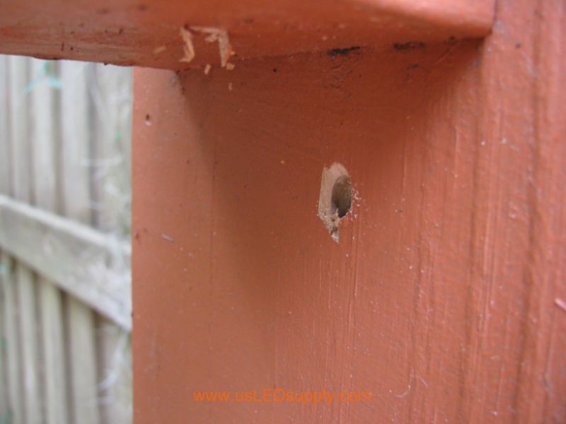 Drilling through a Deck Post in order to run wire through it.  The hole is now completed