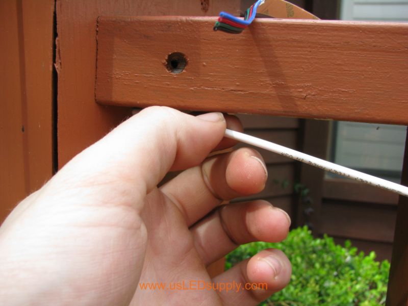 Feeding stiff wire/rod through the hole in the deck post.